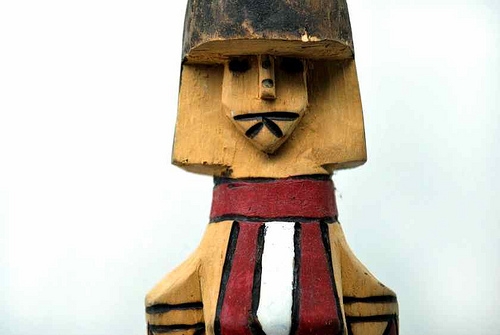 Detalhe de boneco indígena em madeira