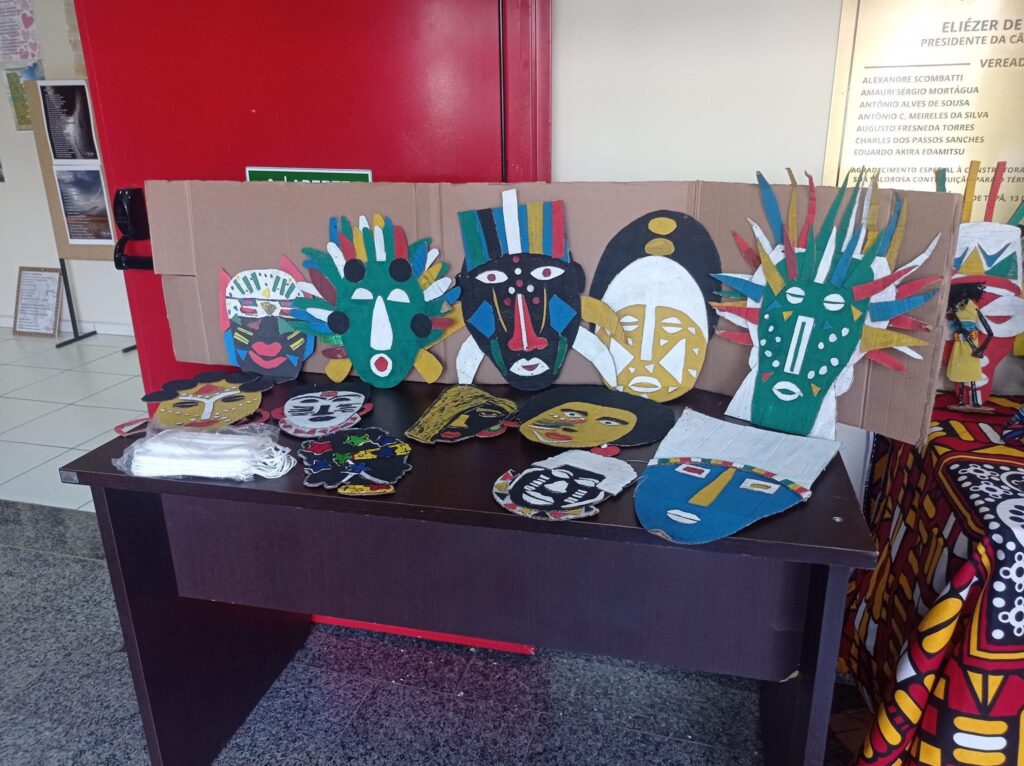 Máscaras feitas na oficina de máscaras expostas em cima de uma mesa